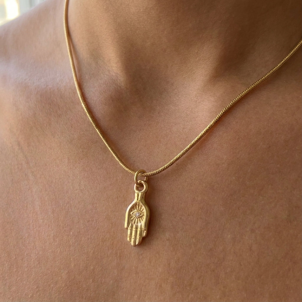 Gouden halsketting met een hamsahand